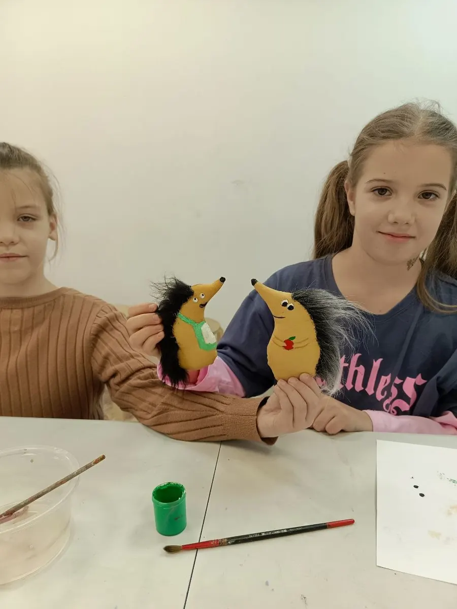 Ученицы показывают игрушечных ёжиков ручной работы